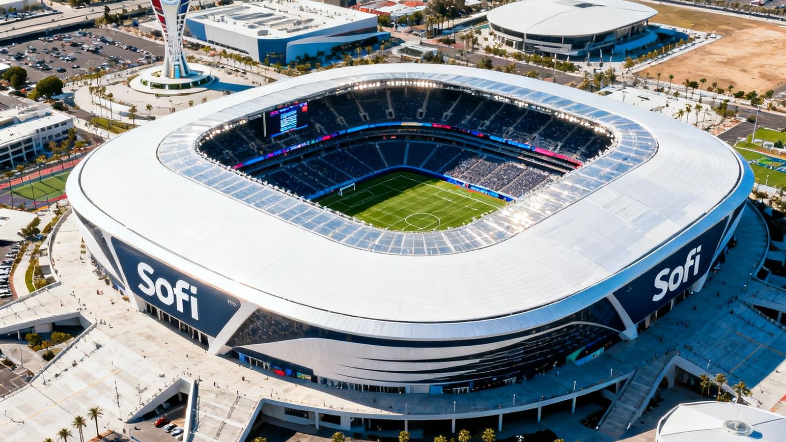 2026年世界杯联合主办城市之一洛杉矶的SoFi体育场航拍全景图，现代化场馆在阳光下熠熠生辉，周边配套设施完善。